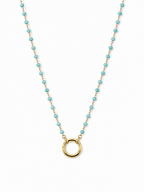 A delicate gold chain necklace featuring small, evenly spaced light blue-green beads and a polished gold open circle pendant, displayed on a clean white background.