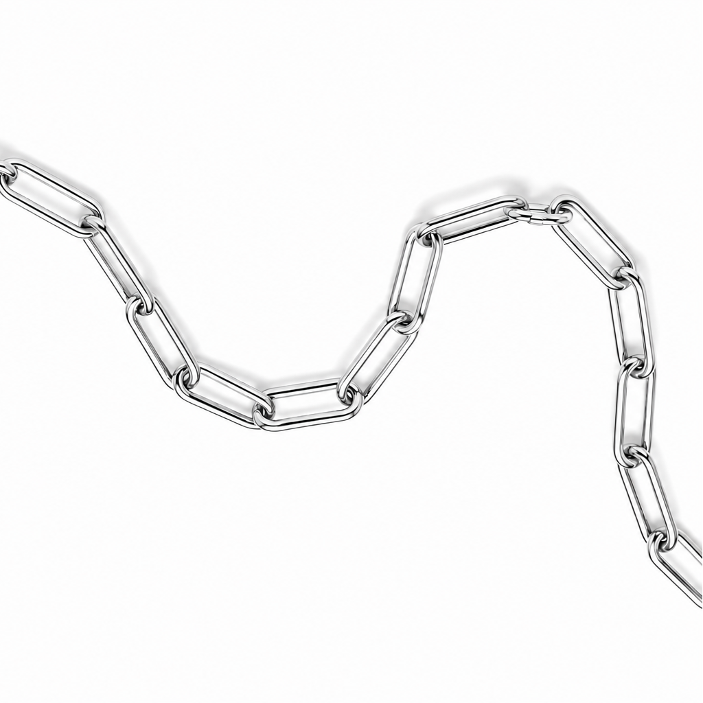 A silver paperclip chain necklace arranged in a wavy line on a plain white background.